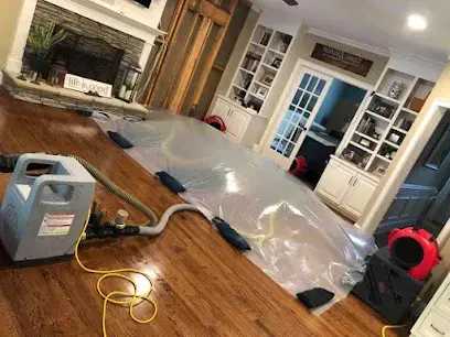 Floor drying setup under plastic on hardwood in an Alhambra home