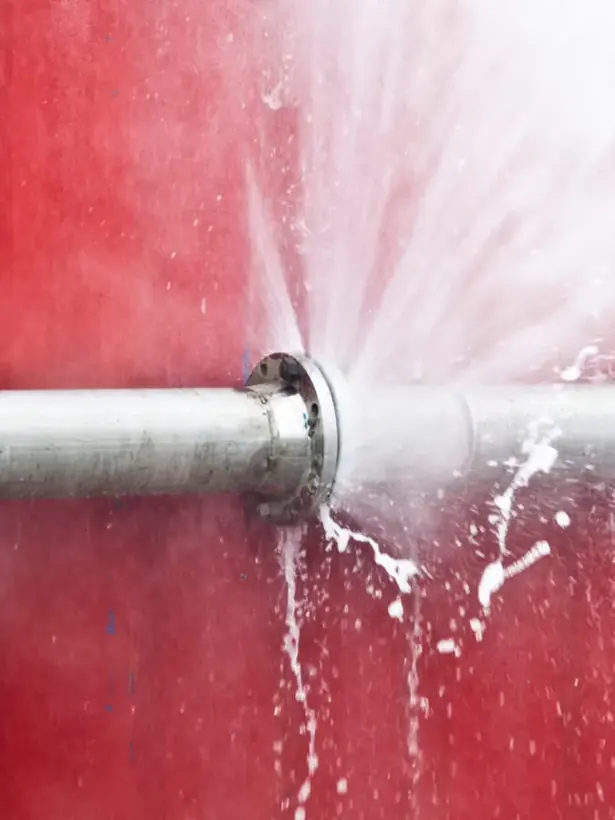 Water spraying from a split supply pipe during a burst pipe loss in Alhambra