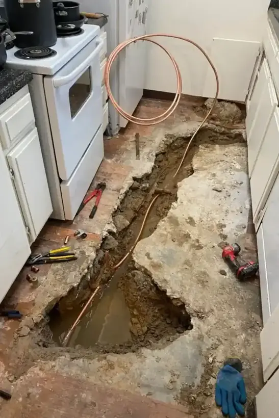 Kitchen slab opened to reach a leaking copper line under an Alhambra floor